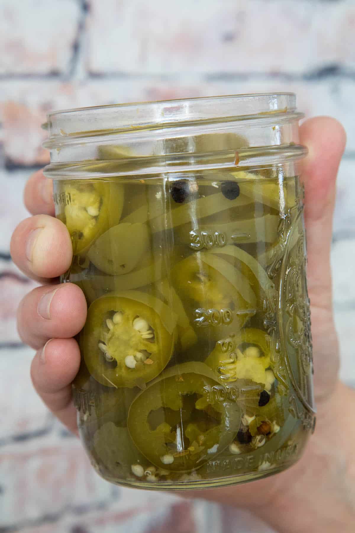 Holding a Jar of Pickled Jalapenos